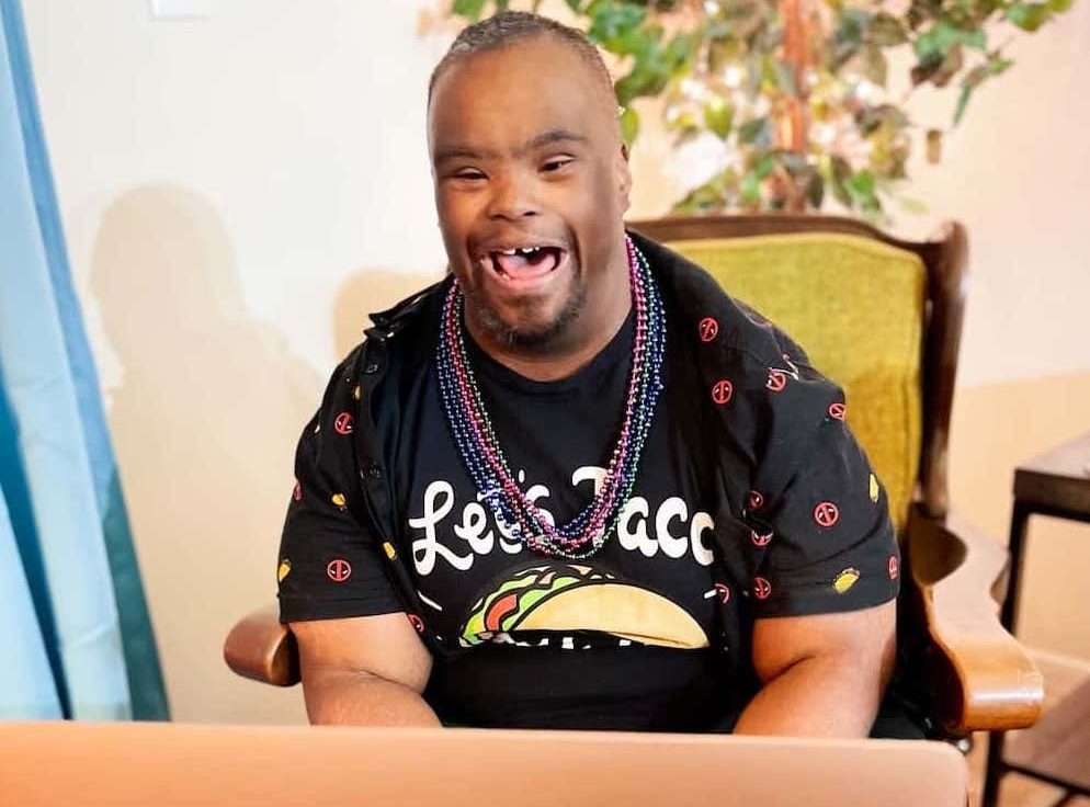 A man sitting in front of a laptop with his mouth open.