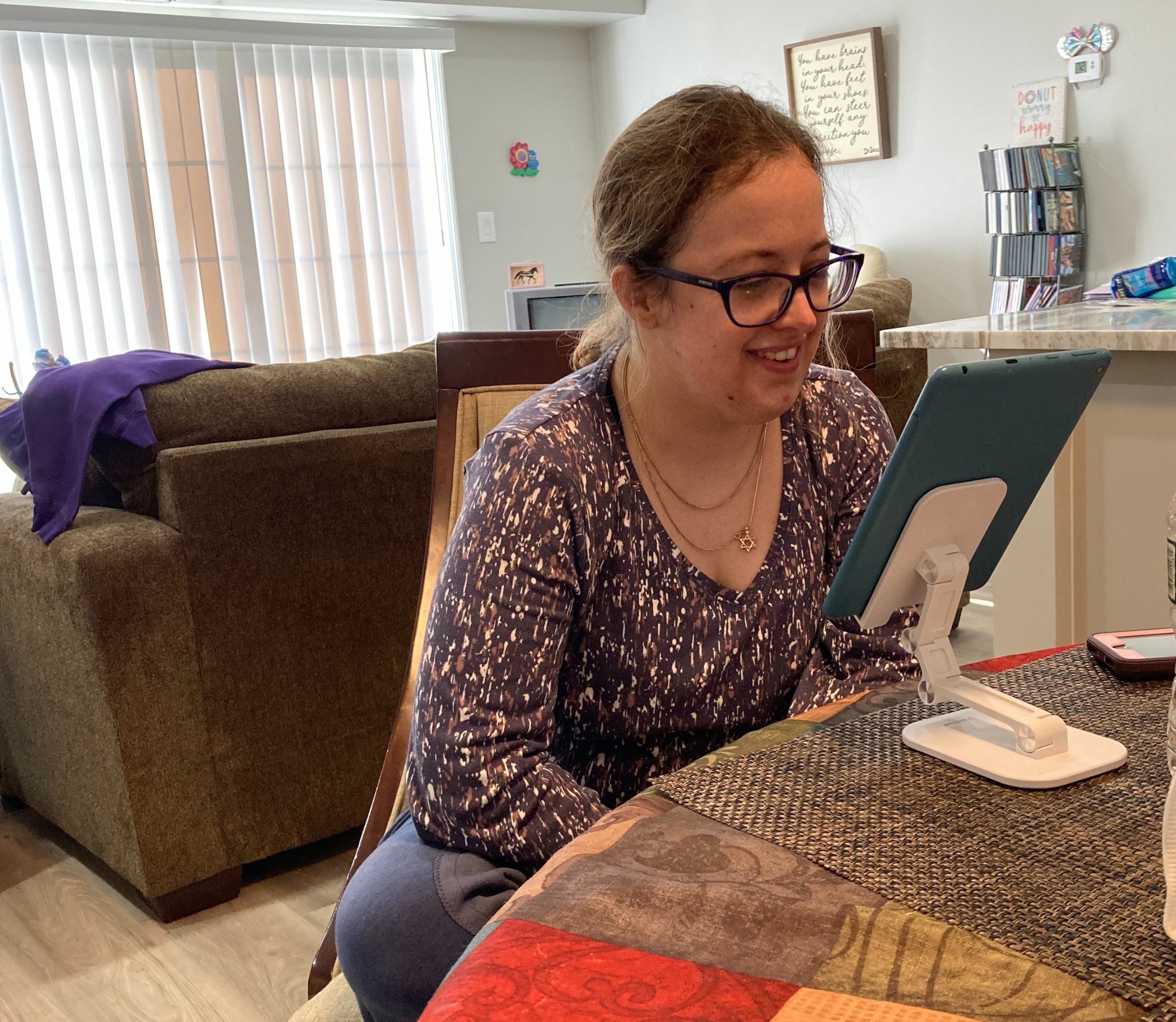 A woman sitting at a table with a tablet computer.