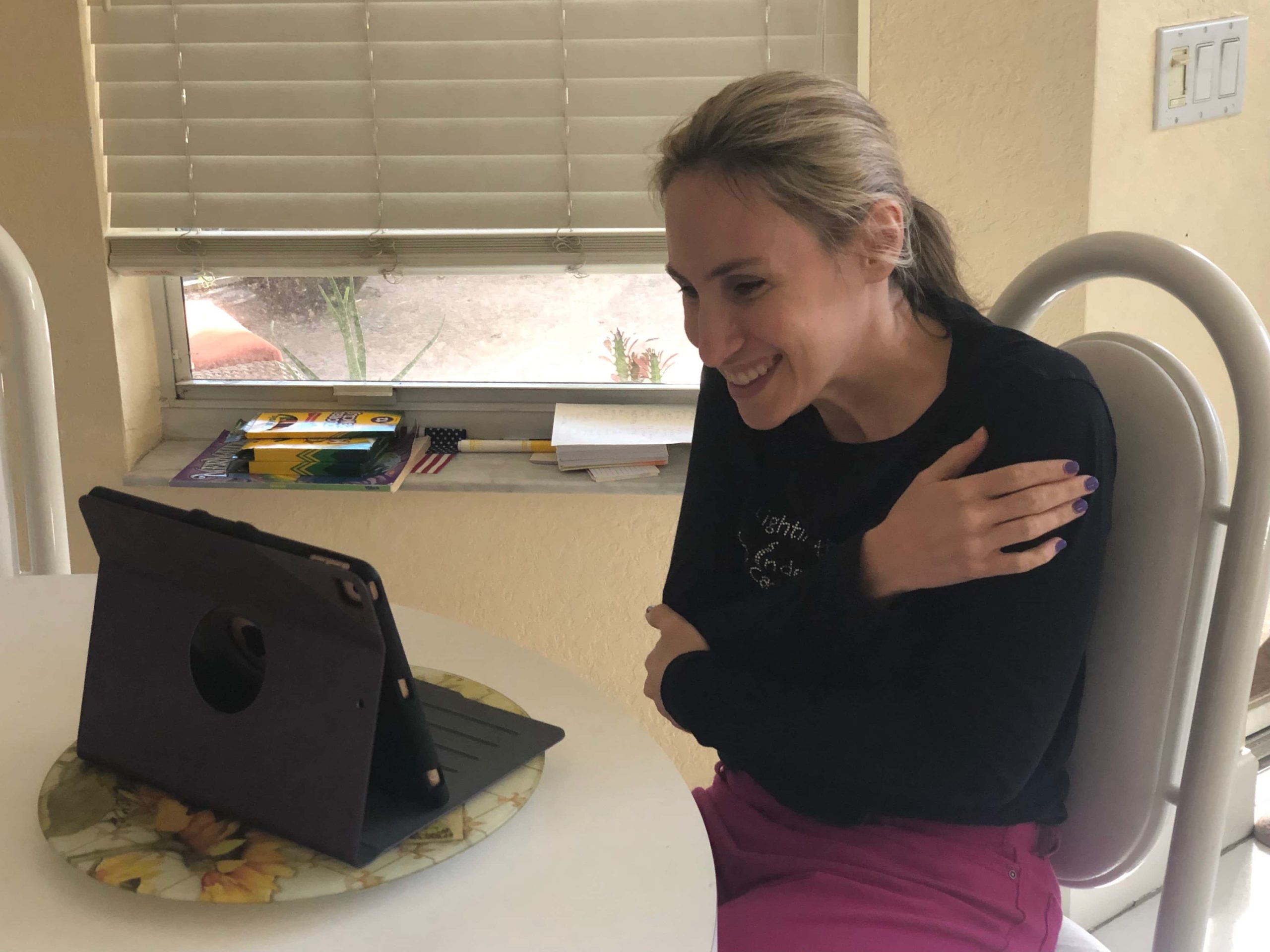 A woman sitting at a table with an ipad.